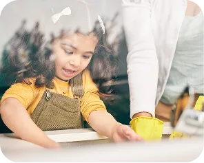 Young child helping clean up with cloth